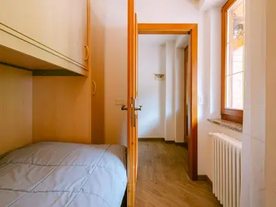 a small bedroom with a bunk bed and a window at Apartment Appartamento Crepaz by Interhome in Canazei