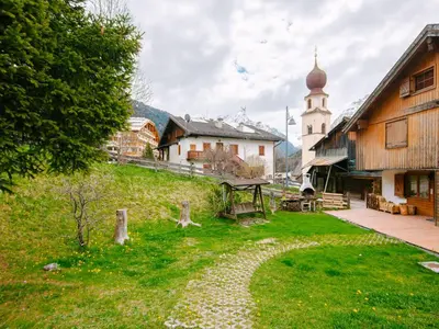 a village with a building and a church at Apartment Appartamento Crepaz by Interhome in Canazei
