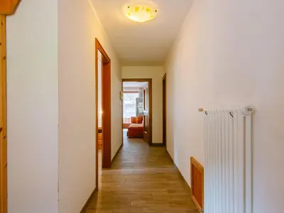 a hallway with white walls and wooden floors and a heater at Apartment Appartamento Crepaz by Interhome in Canazei