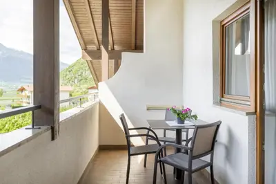 a balcony with a table and chairs and a window at Ferienwohnungen Alber in Rablà
