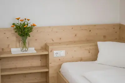 a bedroom with a vase of flowers on a bed at Ferienwohnungen Alber in Rablà
