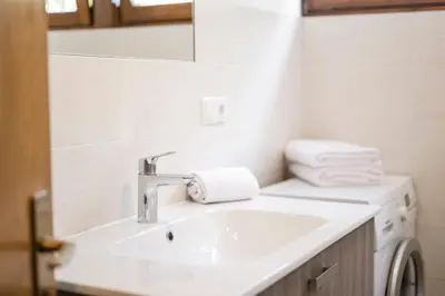 a bathroom with a sink and a washing machine at Ferienwohnungen Alber in Rablà