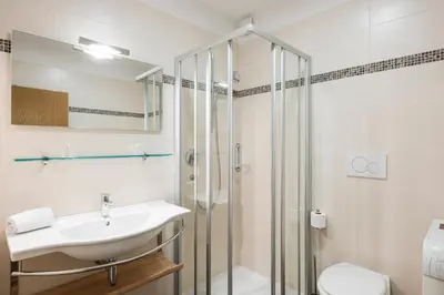 a bathroom with a sink and a shower at Ferienwohnungen Alber in Rablà