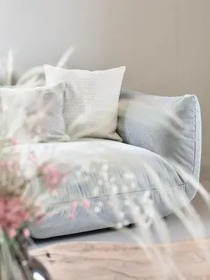 a bed with white pillows and a table with flowers at die Waltraud im Refugium Rochus in Pianizza di Sopra
