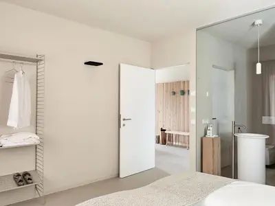 a bedroom with white walls and a large mirror at die Waltraud im Refugium Rochus in Pianizza di Sopra