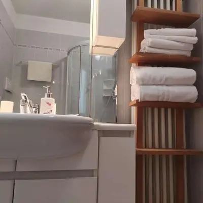 a bathroom with a sink and a stack of towels at Casa San Valentino Dolomiti Val di Zoldo in Val di Zoldo