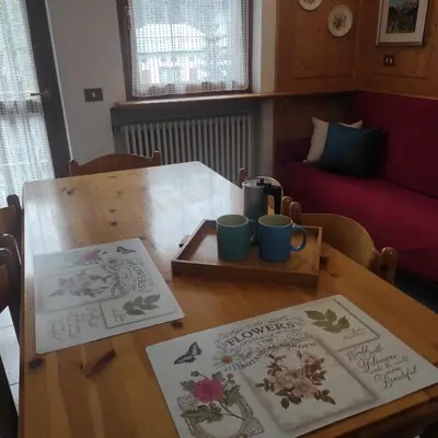 a wooden table with two mats on top of it at Casa San Valentino Dolomiti Val di Zoldo in Val di Zoldo
