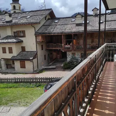 an old building with a bridge in front of it at Casa San Valentino Dolomiti Val di Zoldo in Val di Zoldo