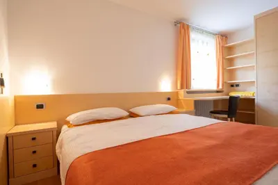 a bedroom with a bed with two pillows and a window at Cesa Delba in Canazei
