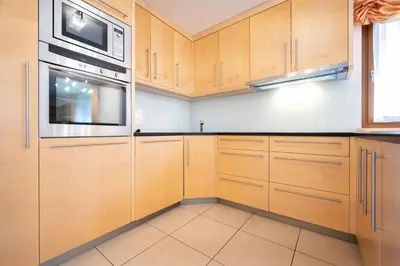 a kitchen with wooden cabinets and a microwave at Cesa Delba in Canazei