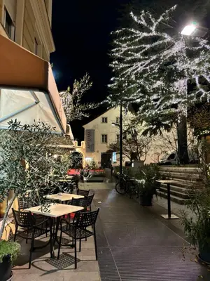 a patio with tables and chairs and a christmas tree at Darling Home in Merano