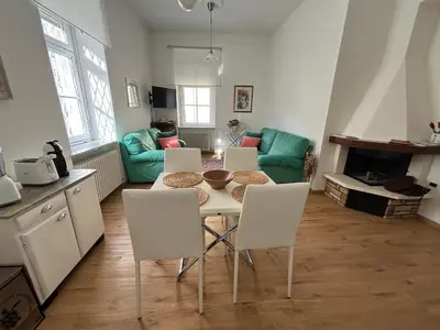 a kitchen and living room with a table and chairs at Darling Home in Merano