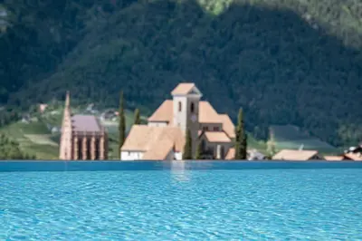 a house sitting on top of a large body of water at Hotel Sunnwies in Schenna