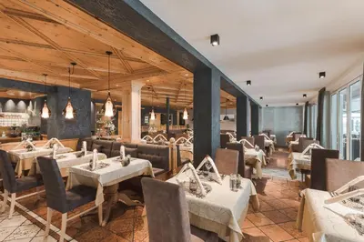 a restaurant with tables and chairs in a room at Hotel Sunnwies in Schenna