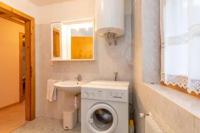 a bathroom with a washing machine and a sink at Casa Soreje in Mazzin