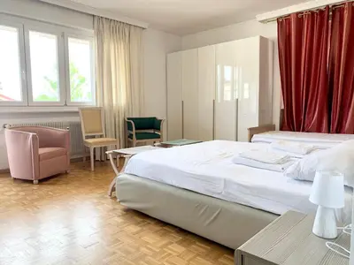 a bedroom with a large bed with red curtains at Appartamento Bolzano - Vittorio Veneto - Parcheggio incluso in Bolzano