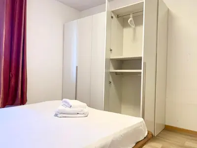 a bedroom with a bed and a closet at Appartamento Bolzano - Vittorio Veneto - Parcheggio incluso in Bolzano