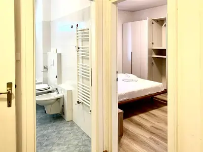 a room with a bathroom with a bed and a toilet at Appartamento Bolzano - Vittorio Veneto - Parcheggio incluso in Bolzano