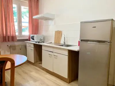 a kitchen with a refrigerator and a sink and a table at Appartamento Bolzano - Vittorio Veneto - Parcheggio incluso in Bolzano