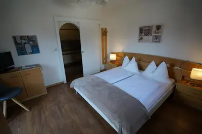 a bedroom with a bed and a desk with two lamps at Residence Rebgut in Tesimo
