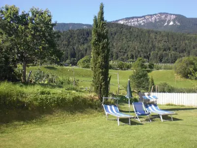 three chairs and a table with an umbrella in a yard at Residence Rebgut in Tesimo