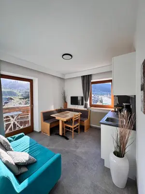 a living room with a blue couch and a table at Residence Rebgut in Tesimo