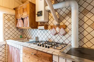 a kitchen with a stove top and a sink at Chalet alla Perla, Grumes in Grumes