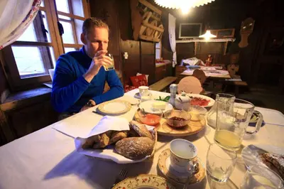a man sitting at a table with a plate of food at Botenhof - Urlaub auf dem Bauernhof - Agriturismo in Sarntal