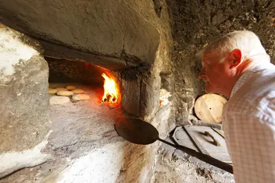 a man standing in front of a brick oven at Botenhof - Urlaub auf dem Bauernhof - Agriturismo in Sarntal