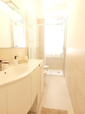 a white bathroom with a sink and a shower at Apartment Ca' de Bezzi in Bolzano