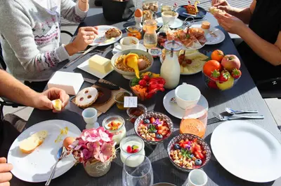a group of people sitting around a table with food at Hillepranter in Marlengo