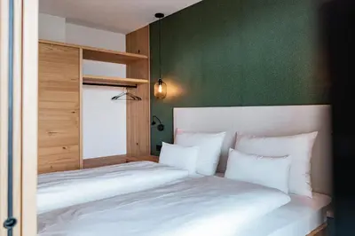 a bedroom with two beds and a green wall at Hillepranter in Marlengo