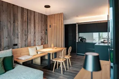 a living room with a bench and a table and a kitchen at Hillepranter in Marlengo