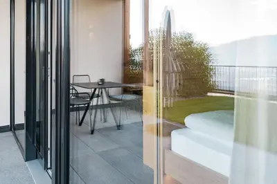 a room with a balcony with a table and a glass door at Hillepranter in Marlengo