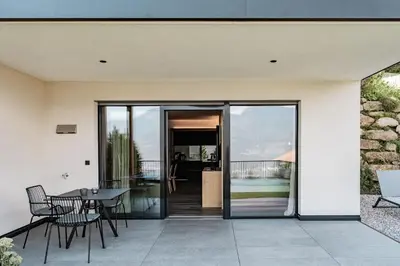 a house with a patio with a table and chairs at Hillepranter in Marlengo