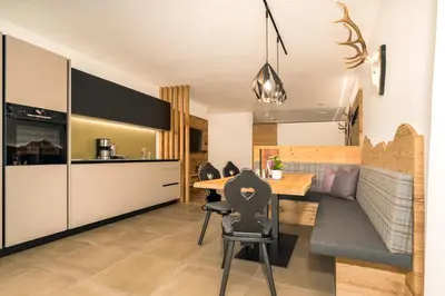 a kitchen and living room with a table and a couch at Apartments Baumann Living in Rodengo