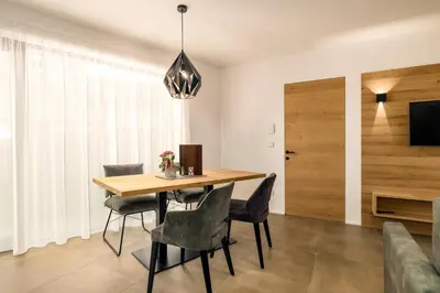 a dining room with a wooden table and chairs at Apartments Baumann Living in Rodengo