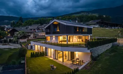 a house on a hill with its lights on at Apartments Baumann Living in Rodengo