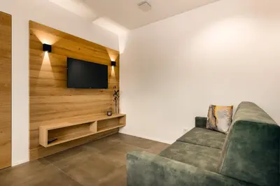 a living room with a couch and a flat screen tv at Apartments Baumann Living in Rodengo
