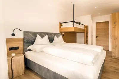 a bedroom with a large bed with white sheets at Apartments Baumann Living in Rodengo