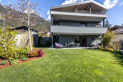 a house with a lawn in front of it at Mali Apartments Garden Suite in Tirolo