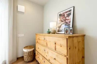 a room with a wooden dresser with a picture on it at Mali Apartments Garden Suite in Tirolo