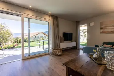 a living room with a large sliding glass door at Mali Apartments Garden Suite in Tirolo
