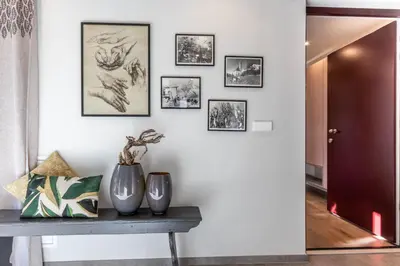 a hallway with a table and pictures on the wall at Mali Apartments Garden Suite in Tirolo