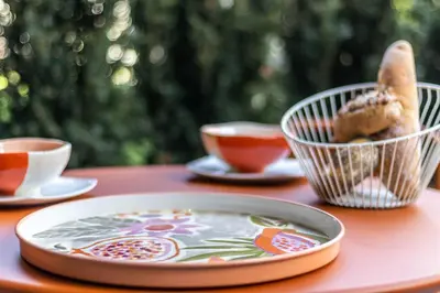 a table with a plate and cups of tea at Mali Apartments Lounge in Tirolo