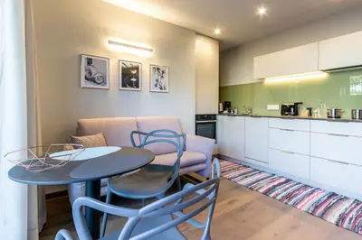 a kitchen and a table and chairs in a room at Mali Apartments Lounge in Tirolo