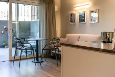 a kitchen and living room with a table and chairs at Mali Apartments Lounge in Tirolo