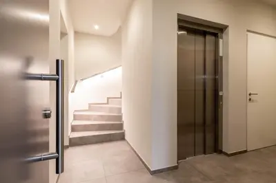 a hallway with a staircase with a door and a stair case at Mali Apartments Lounge in Tirolo