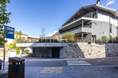 a building with a stone wall next to a street at Mali Apartments Lounge in Tirolo