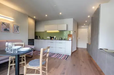 a kitchen and living room with a table and chairs at Mali Apartments Balcony in Tirolo